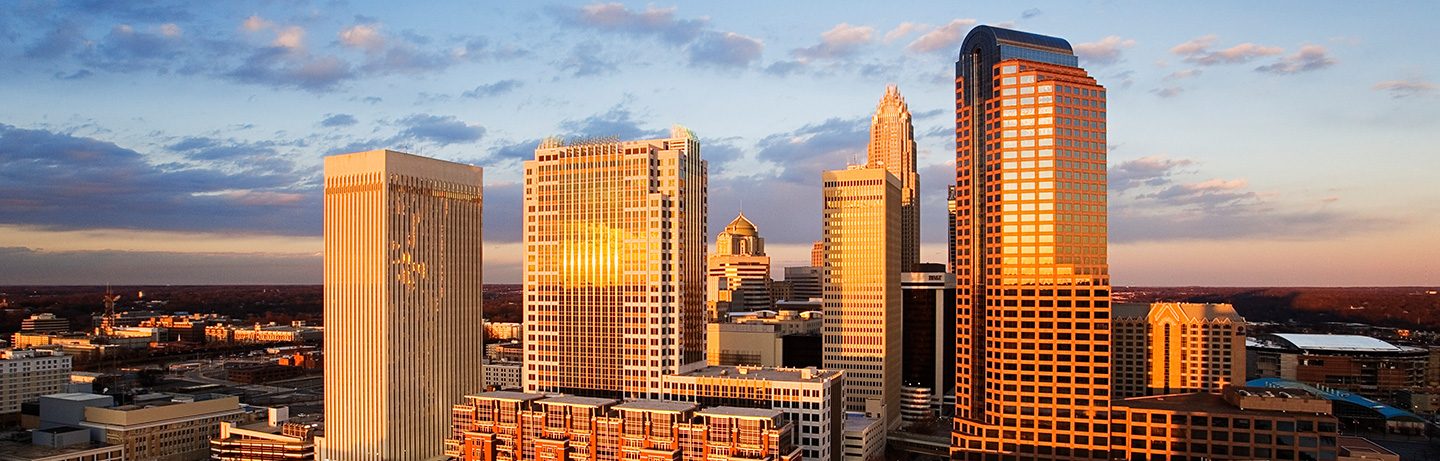 Charlotte skyline at sunset with skyscrapers glowing in golden evening light