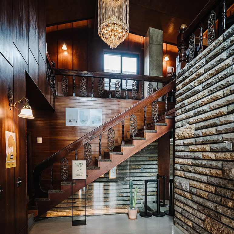 Einblick in das Café Lowkey in Seoul mit einer Holztreppe und einer Ziegelwand
