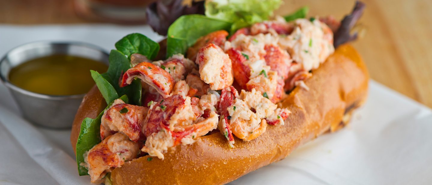 Nahaufnahme eines Lobster Roll in einem gerösteten Brötchen, serviert auf einem Teller