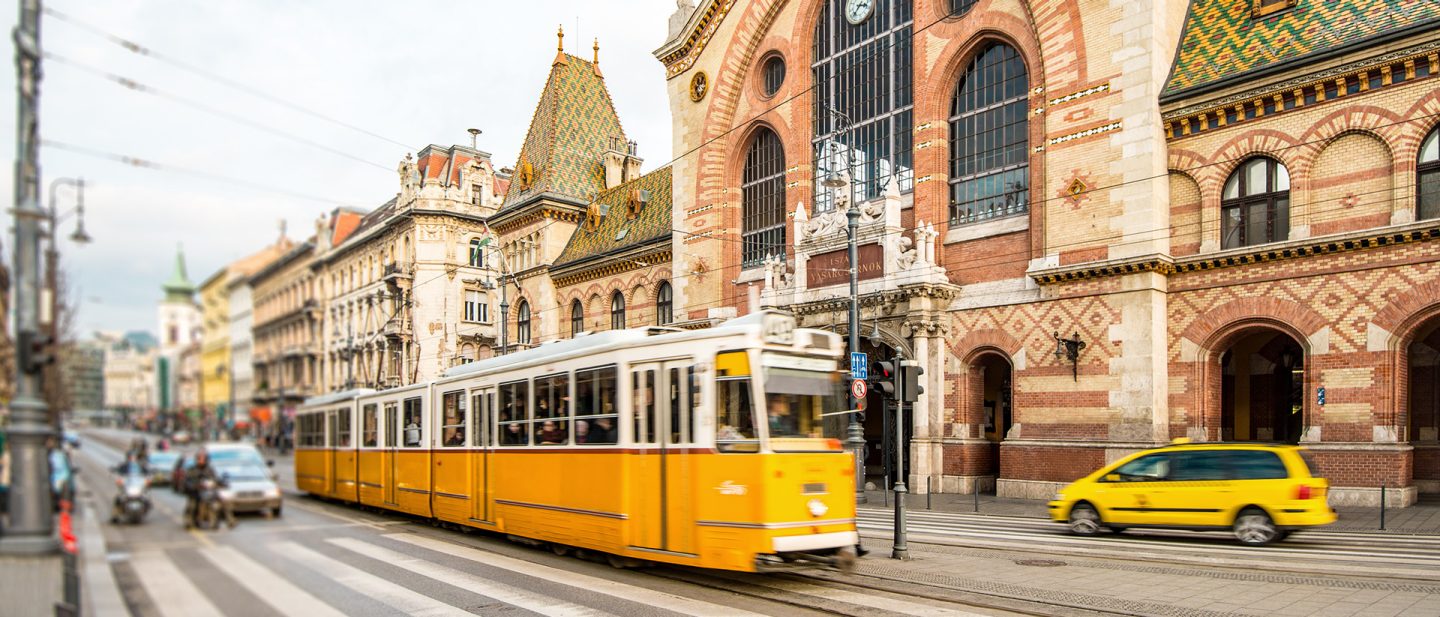 Historische gelbe Tram vor Budapests Großer Markthalle
