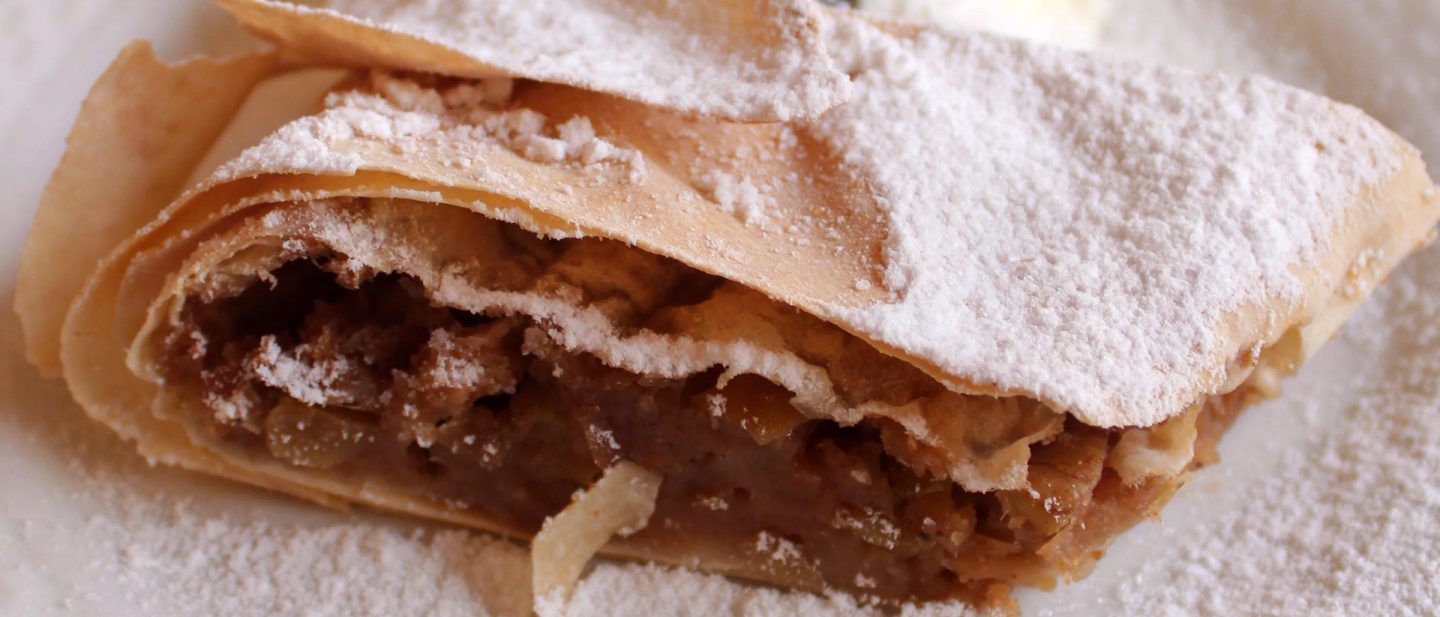 Frischer Strudel mit Puderzucker auf einem Teller