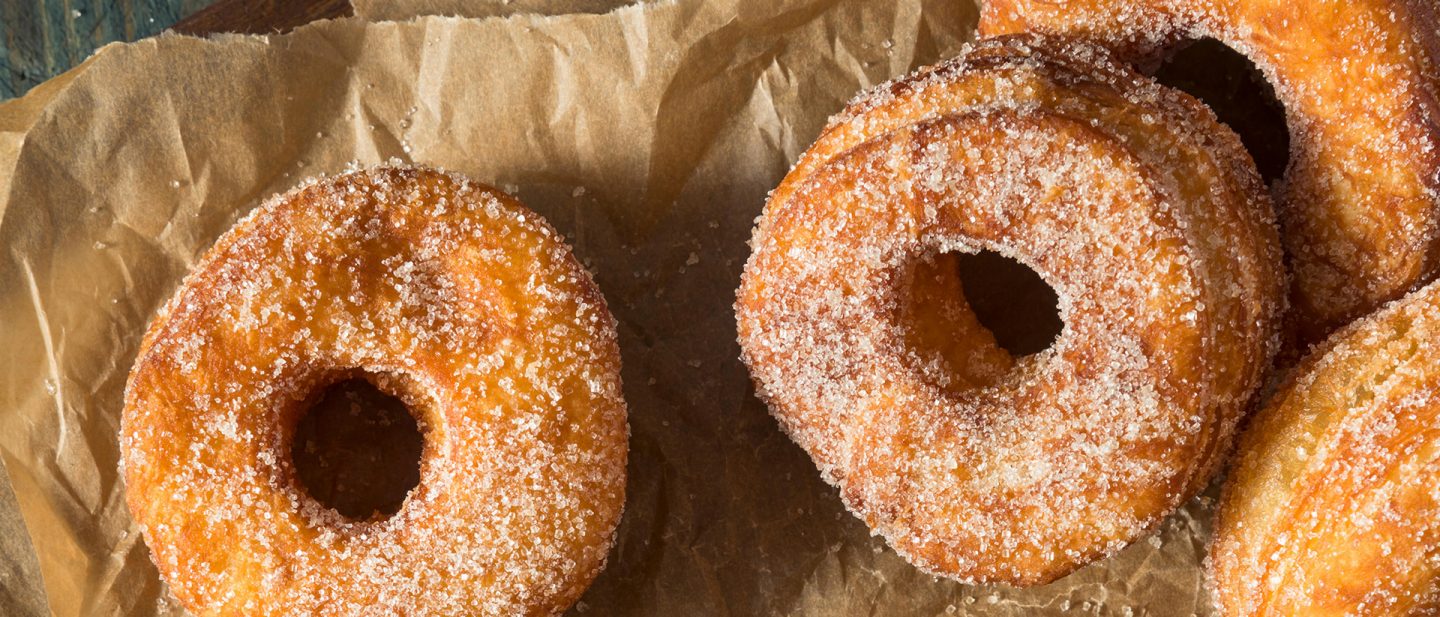 Nahaufnahme von zuckergoldbraunen Cronuts auf Backpapier
