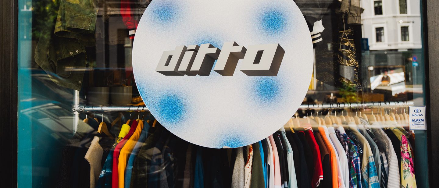Schaufenster des Secondhandladens „Ditto“ mit Kleidung an Bügeln