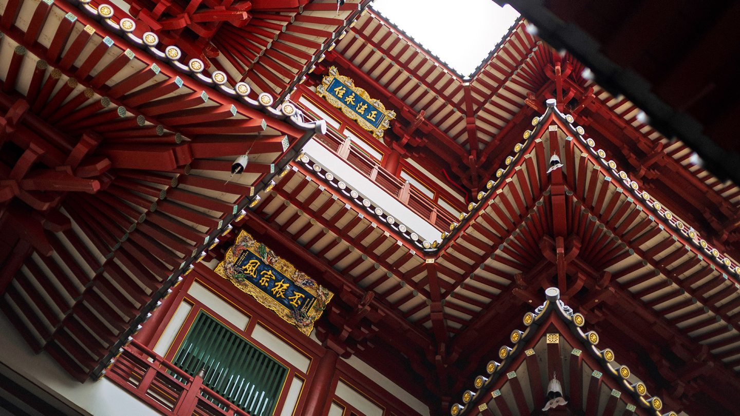 Blick nach oben in den Innenhof eines roten chinesischen Tempeldachs in Chinatown, Singapur