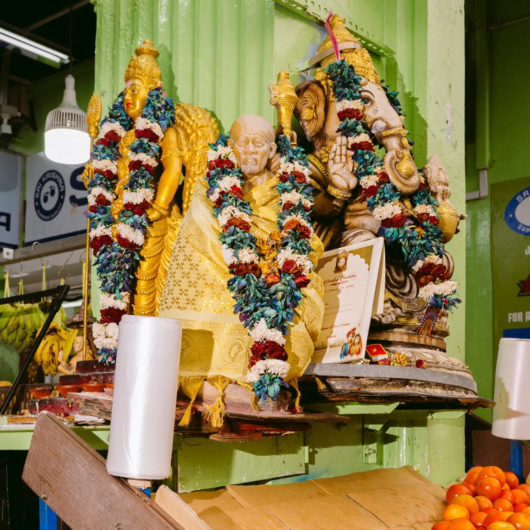 Statuen von Sai Baba, Ganesha und einer Gottheit auf einem Altarschrein in einem Markt