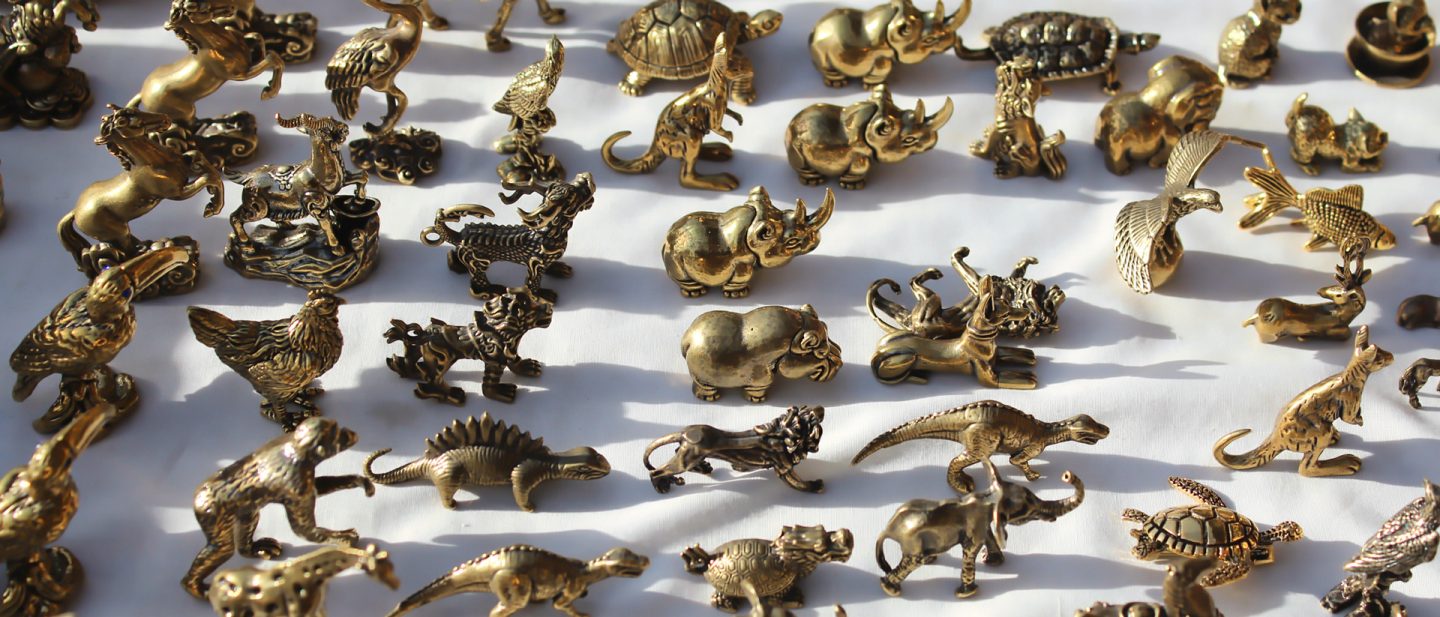 Viele kleine goldene Tierfiguren aus Metall auf Flohmarkt in Riad, darunter Nashörner, Löwen und Schildkröten