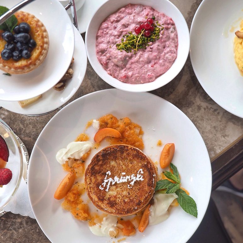 Verschiedene Gourmet-Frühstücksgerichte, darunter eine Custard-Tarte, Haferbrei mit gemischten Beeren und eine Crème brulée